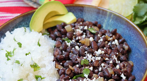 Healthy low carb konjac rice and beans on plate with lime, avocado, and colorful napkin